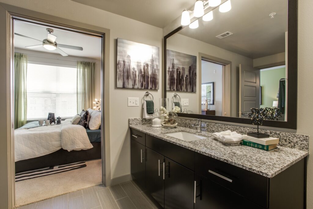 Bathroom with large mirror, designer lighting and granite counters with single sink